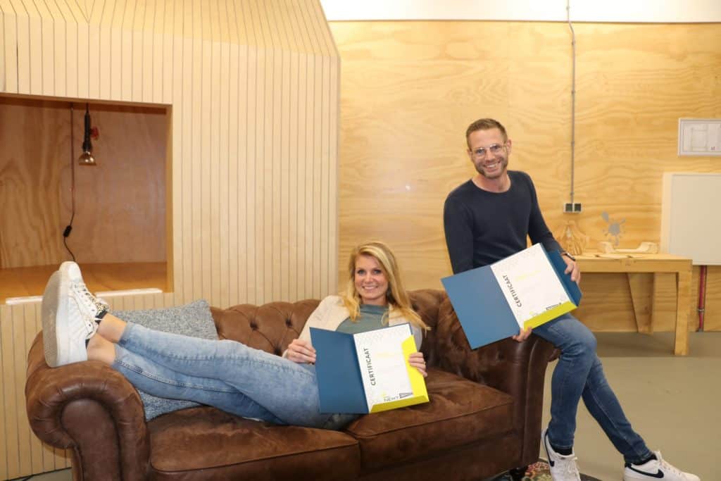 Twee deelnemers van een training van Cibap Next poseren op een bank in de ontwerpfabriek bij Cibap vakschool