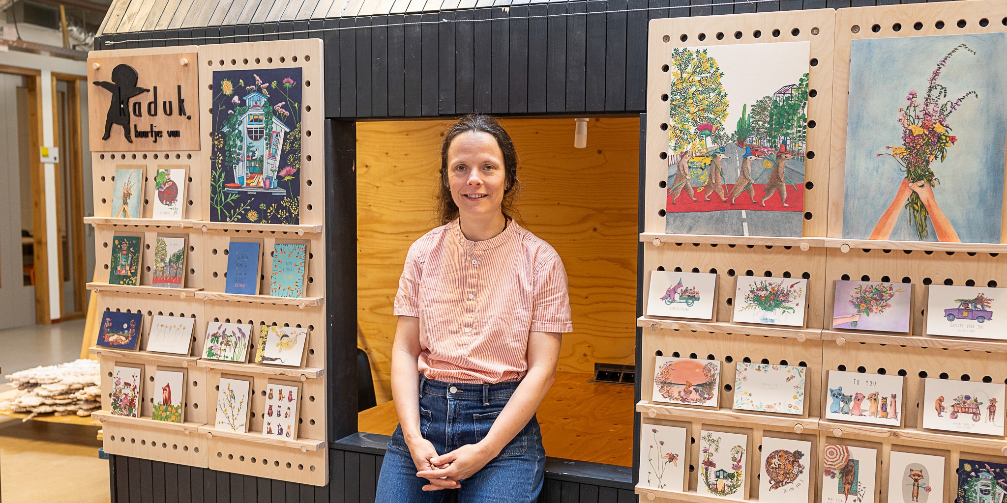 Katja Kaduk, deelnemer van de training meubelmaken basis van Cibap Next, naast haar zelf ontworpen meubelstuk van hout: een modulair kaartenrek voor haar illustraties.